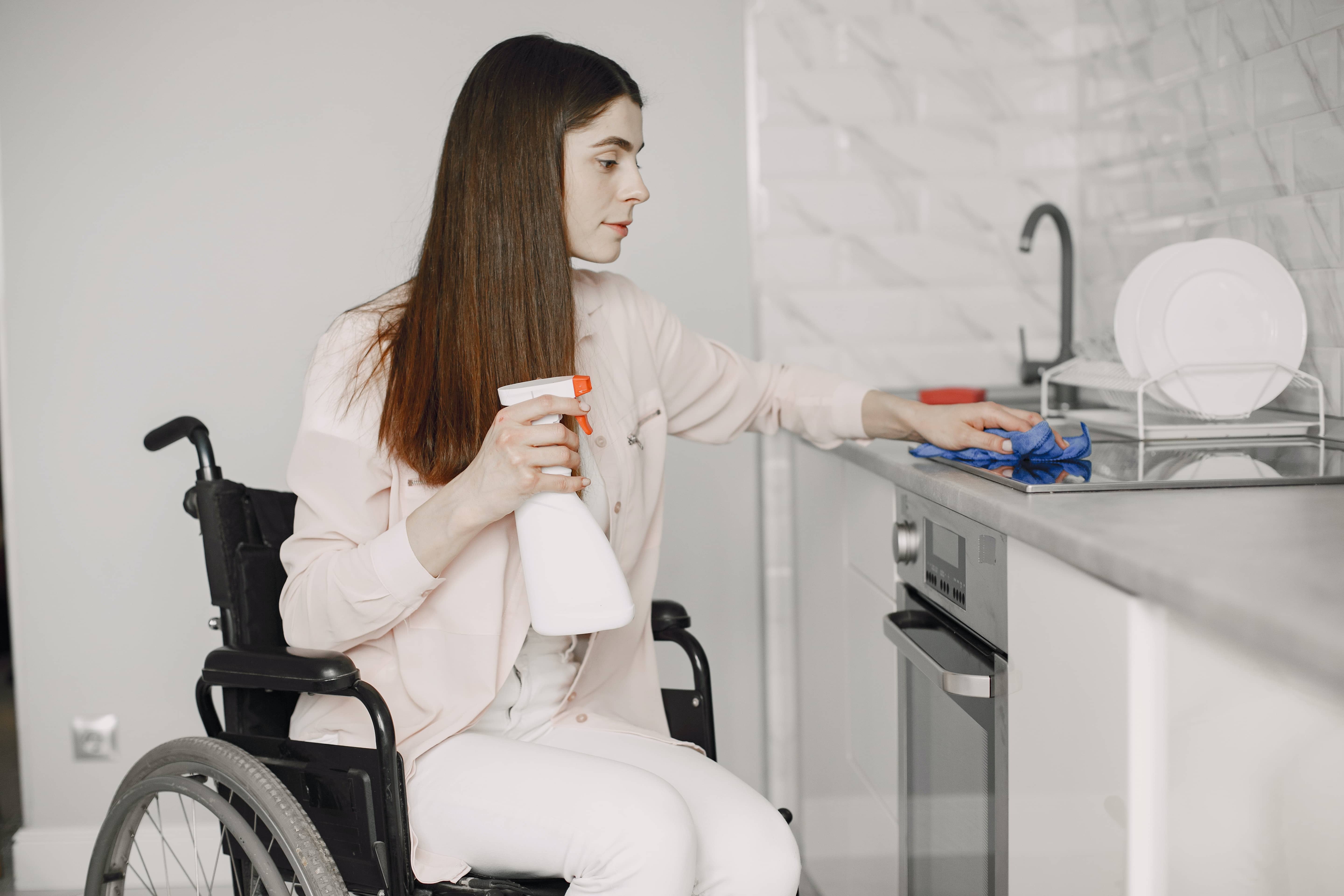 woman cleaning kitchen bench
