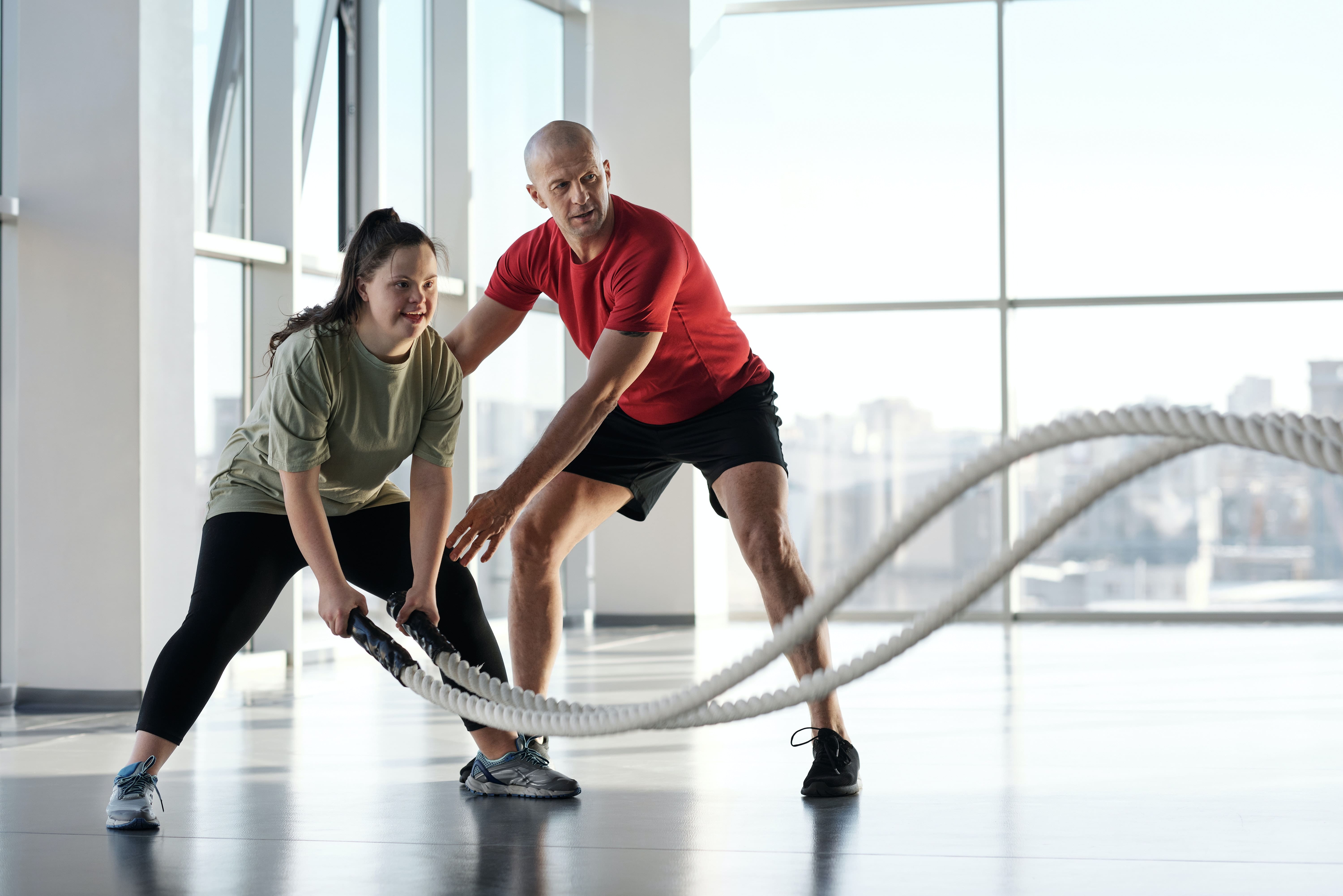 Photo of exercise trainer training a young woman with disability