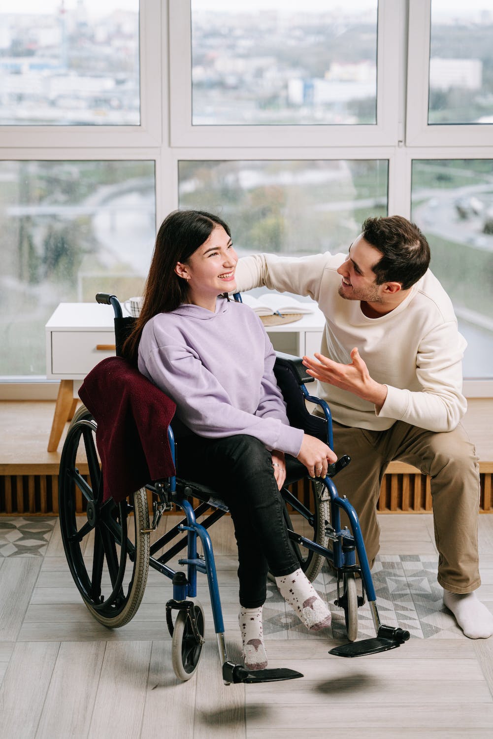 Image of support worker similing with client on a wheel.